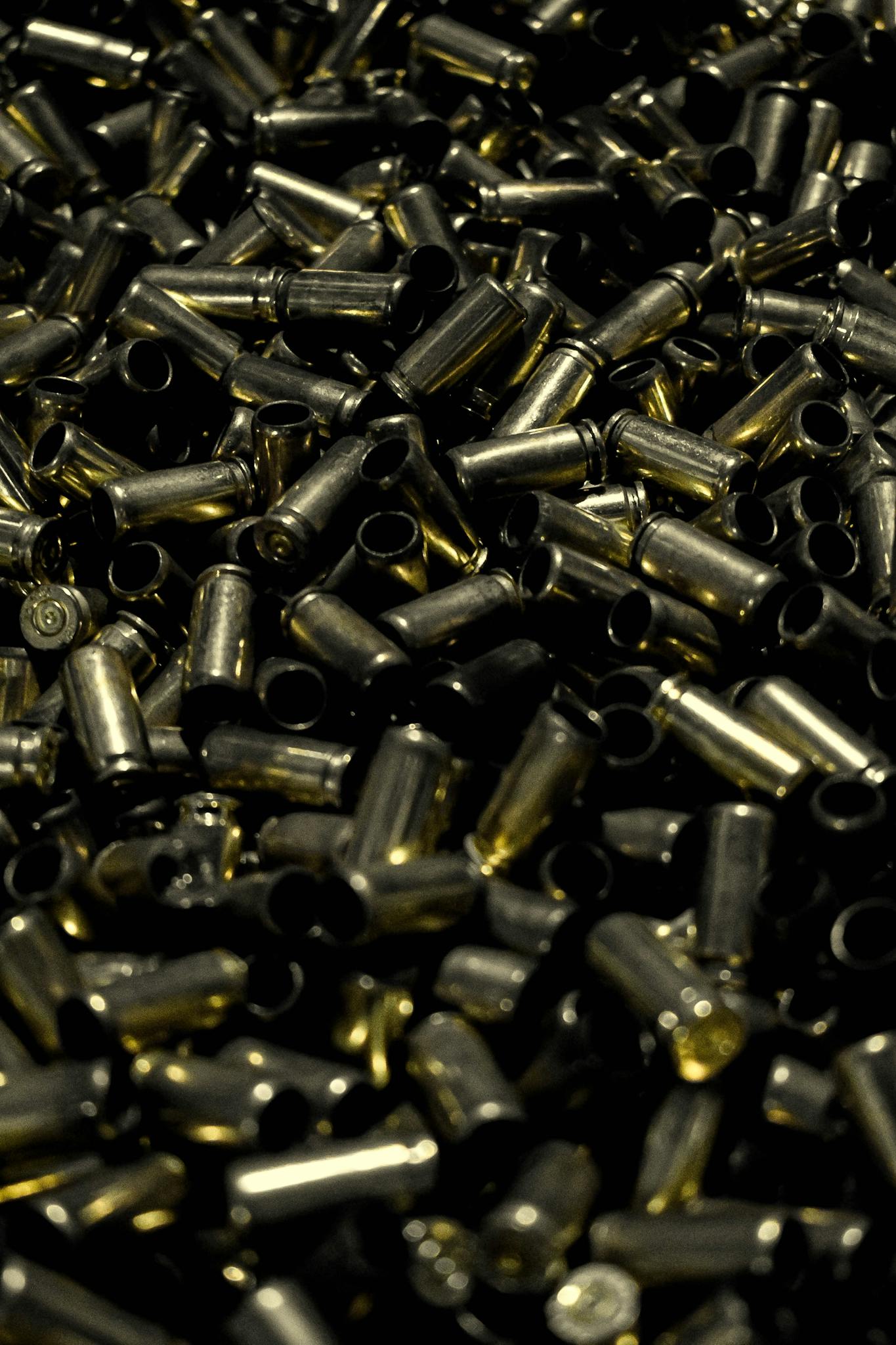 A detailed close-up shot of a large pile of brass bullet casings.