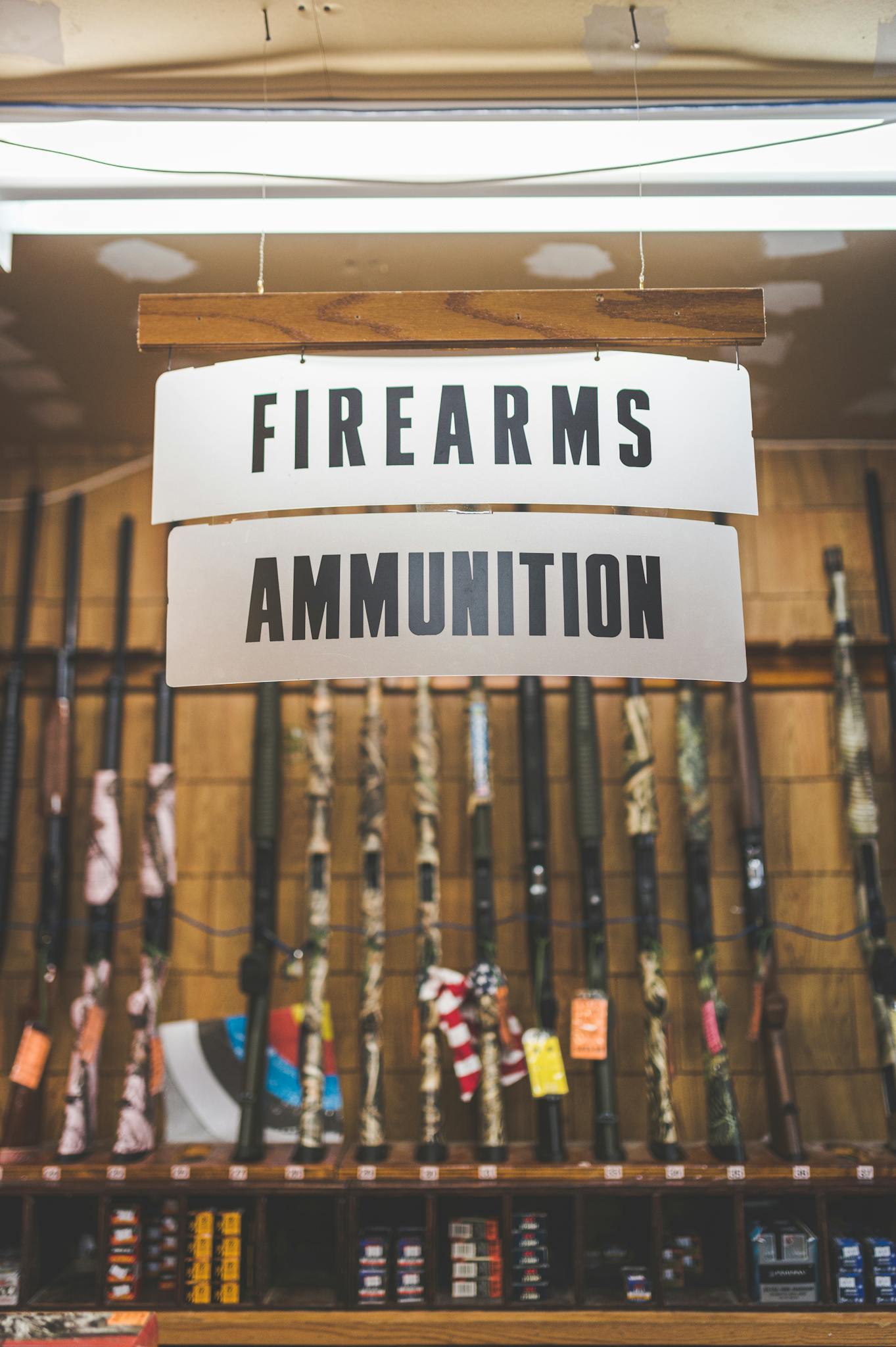 Signage in a firearms and ammunition store showcasing rifles and related products.
